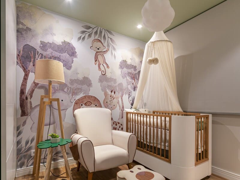 Quarto de bebê com tema safari, destacando papel de parede personalizado com animais.